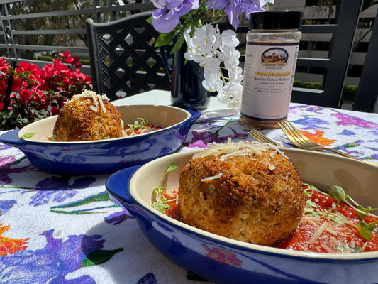 2 large meatballs plated with marinara sauce. Photo Courtesy of MyCuratedTastes