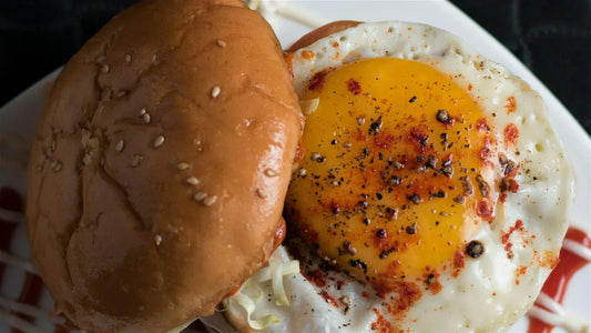 Sesame seed bun, fried egg with fresh seasoning over the top. 