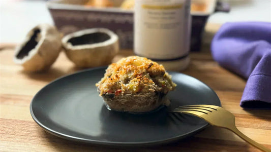 Stuffed Mushroom on a black plate, golden brown crust over the top. 