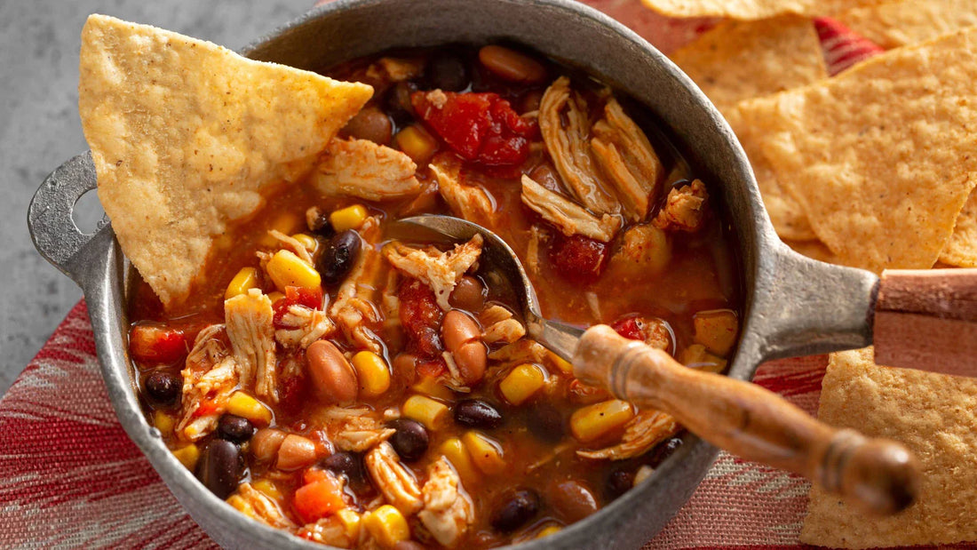 Taco Soup in a sauce pan with chips surrounding it. 