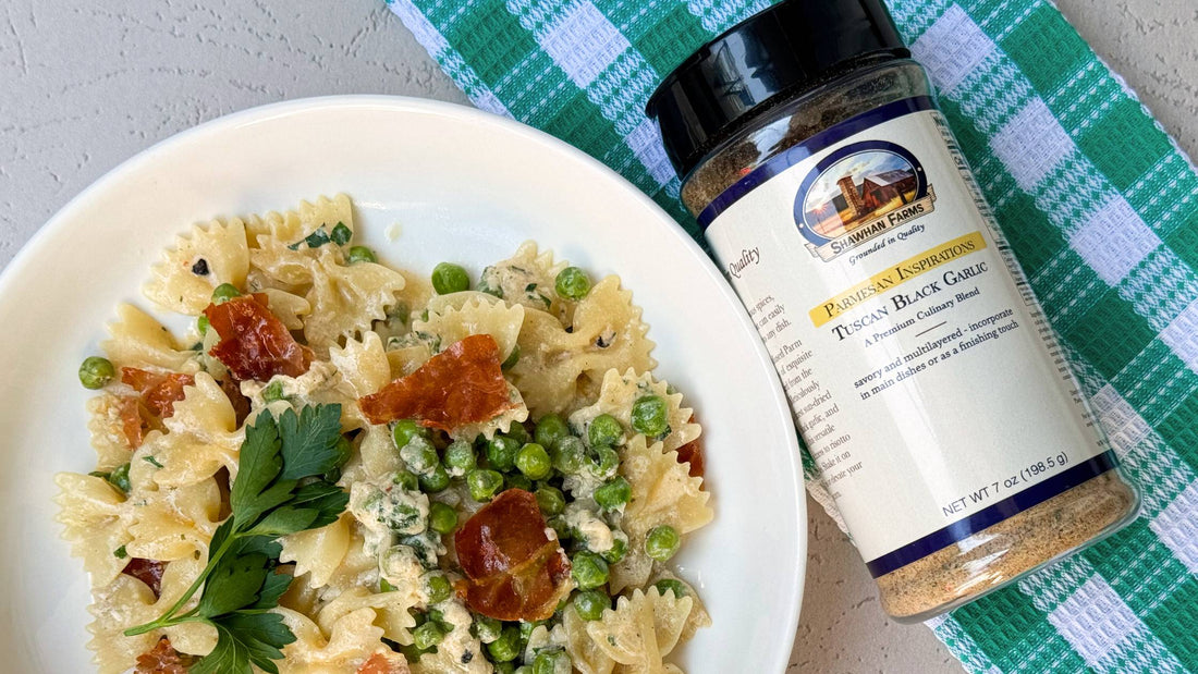 bowtie pasta in a bowl with peas, chicken & greens with a bottle of Tuscan Black Garlic Parmesan next to it. 