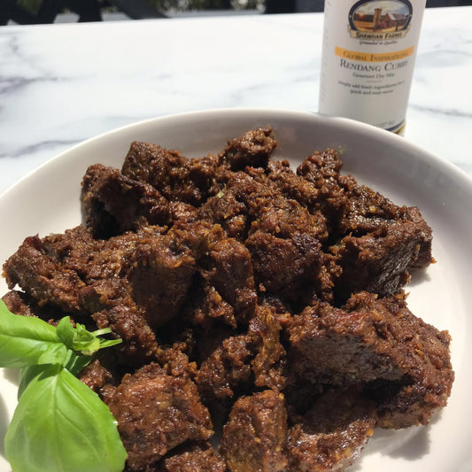 browned beef chunks on a white plate on a marble countertop