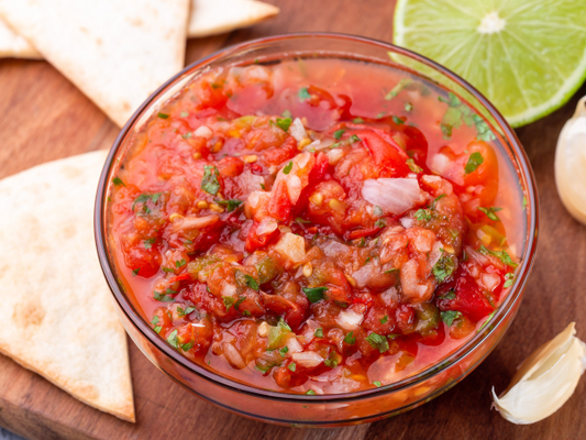 Salsa with herbs onion and garlic in a glass bowl