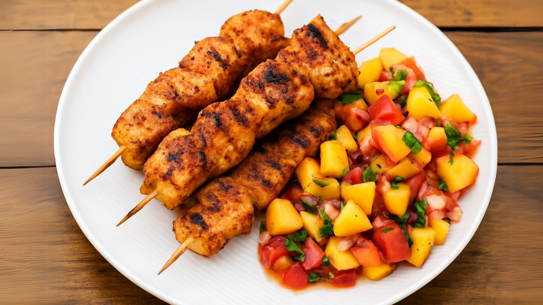 BBQ chicken skewers with peach salsa on a wooden board with lime wedges