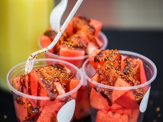 Watermelon in a cup with Chamoy and Tajin coating the sliced watermelon