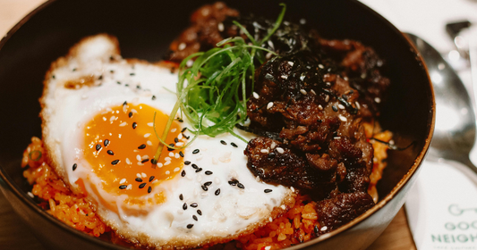 Chili Oil fried rice with a fried egg, some meat, and a green garnish