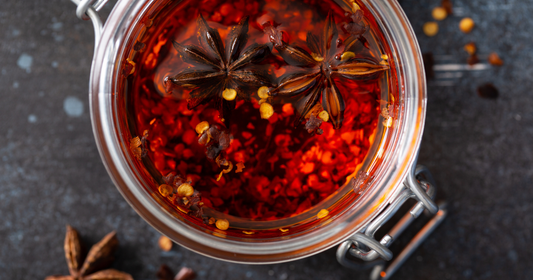 Star Anise floats in the red chili oil in a glass jar